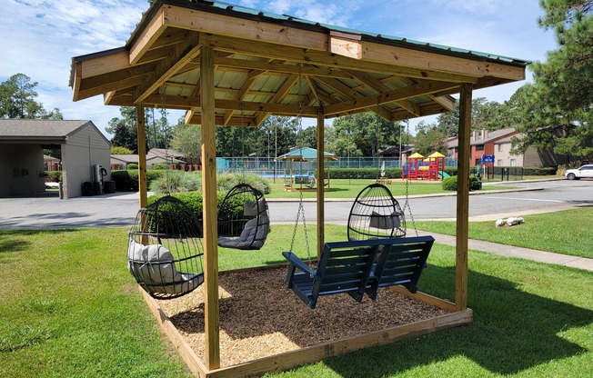 a swing set in a park with a gazebo