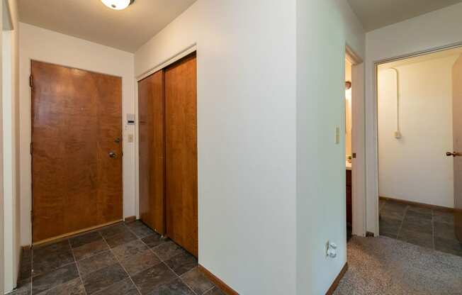 the hallway of a home with two doors and a tile floor. Fargo, ND Islander Apartments