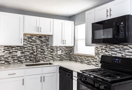 a kitchen with white cabinets and appliances