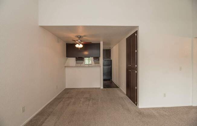 A room with a carpeted floor and a ceiling fan at Pepperwood Apartments, California, 95661