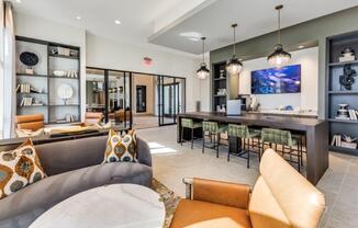 A modern living room with a grey couch and a brown leather chair.