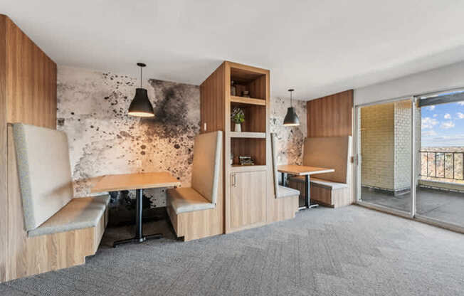 A room with a table, chairs and a wall with a unique design.