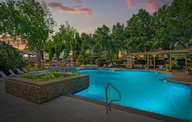 a large swimming pool with trees around it