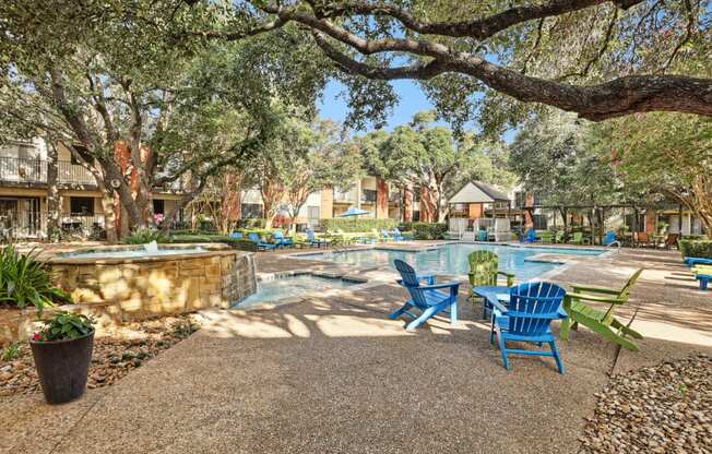 Swimming pool with blue chairs and trees at Hunters Chase in Austin, TX