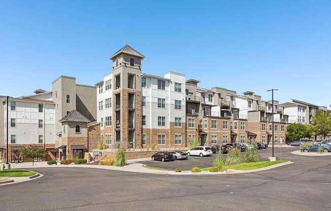 A large apartment complex with a parking lot in front.