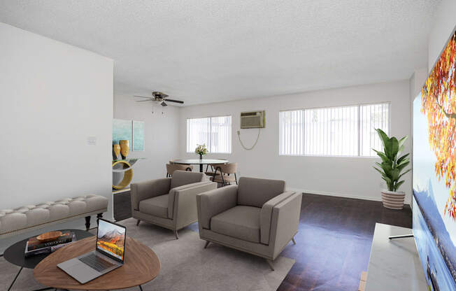 a living room with couches and chairs and a table with a laptop