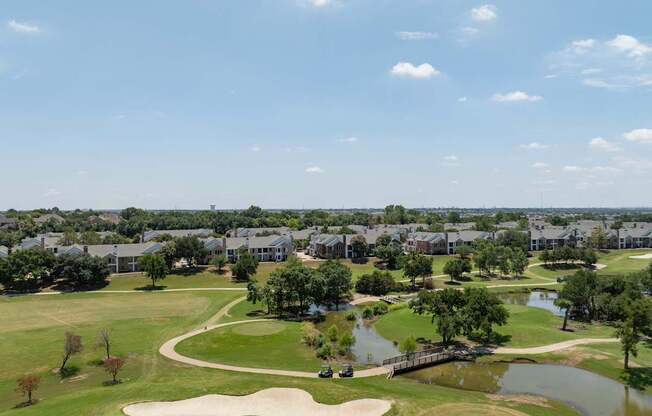 A golf course with a pond and a bridge.