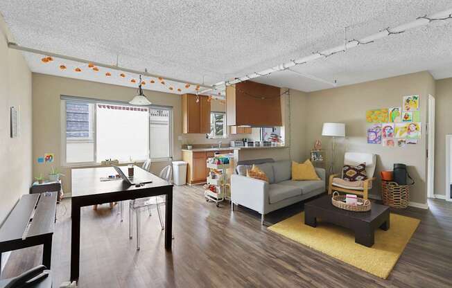 A living room with a couch, coffee table, and a dining table.