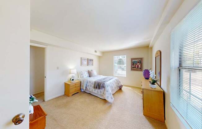 A bedroom with a bed, nightstand, and window.