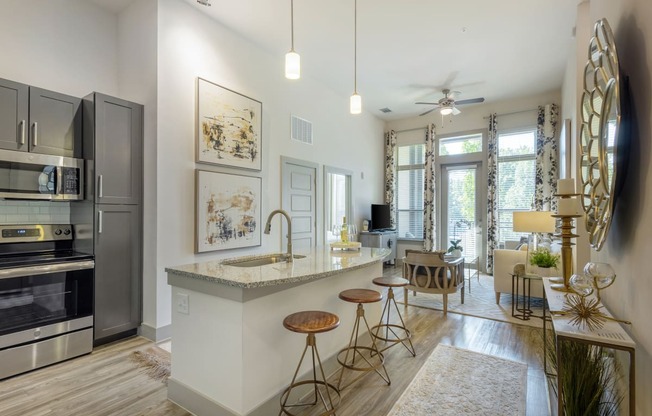 an open kitchen and living room with a bar and stools