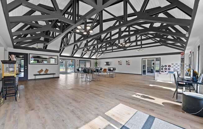 A spacious room with a high ceiling and wooden flooring.