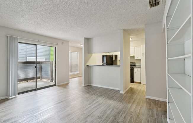 an open living room and kitchen with a sliding glass door