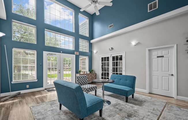 A blue chair and a blue sofa are in a room with a ceiling fan.