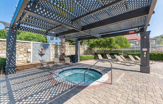 hot tub under pergola with chairs nearby
