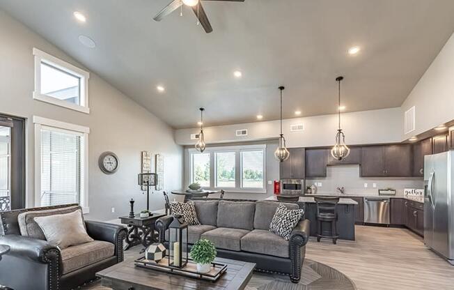 a living room with couches a coffee table and a kitchen in the background