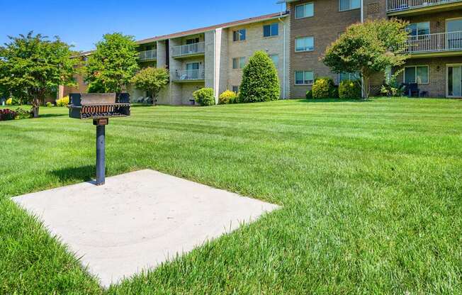 a mailbox in the middle of a lawn in front of an apartment building