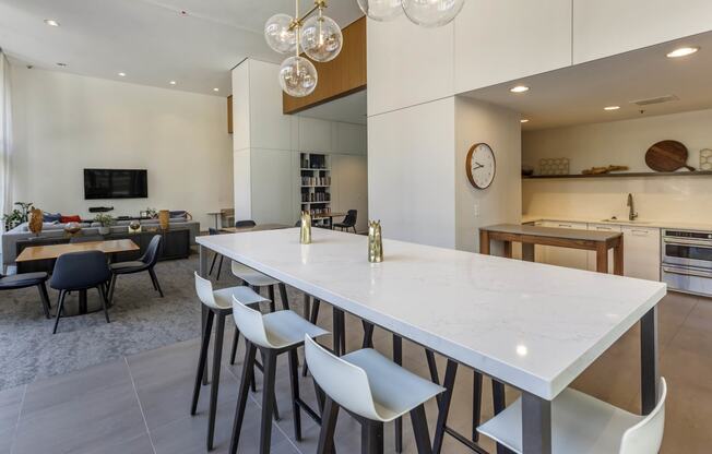 a long white table in the center of a kitchen and living room at North Harbor Tower, Chicago, 60601