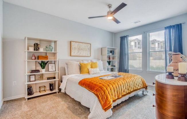 a bedroom with a bed and a ceiling fan  at Edge and Stone, San Antonio, 78260