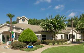 a house with a lawn and trees in front of it