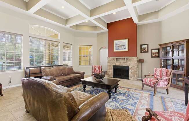 A living room with a brown leather couch and a fireplace.