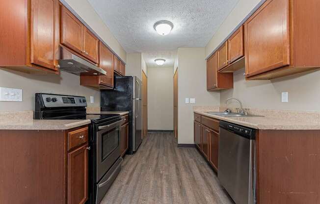 A kitchen with brown cabinets and black appliances.