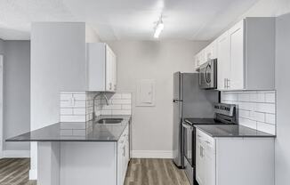 a kitchen with white cabinets and stainless steel appliances