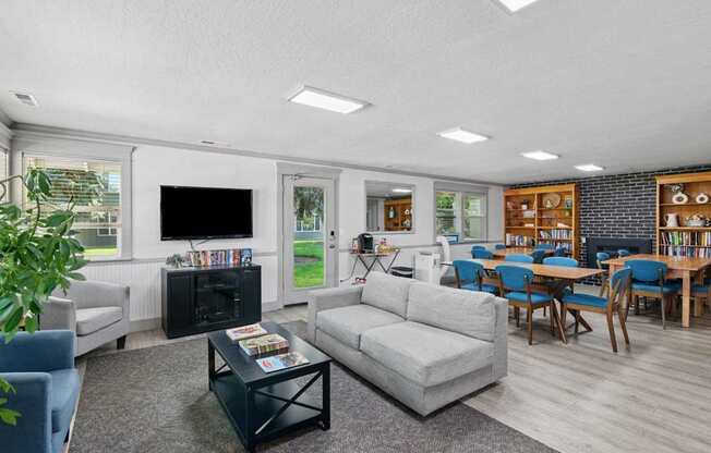 A living room with a grey couch, a black coffee table, and a television.
