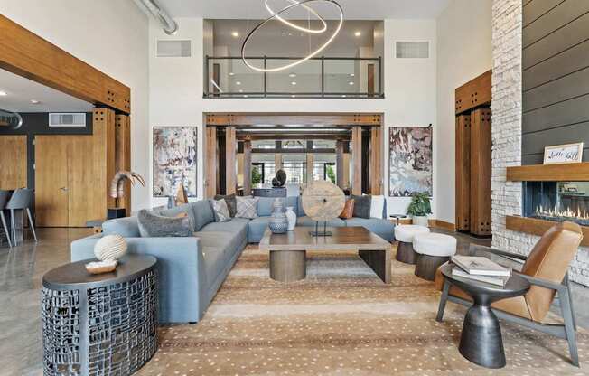 a living room with blue couches and chairs and a large window