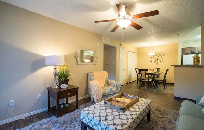 A bedroom with a bed, a chair, a table, and a ceiling fan at Sterling Point Apartment Homes, Phoenix