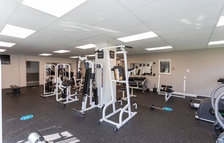 A gym with a variety of equipment including weights and machines.