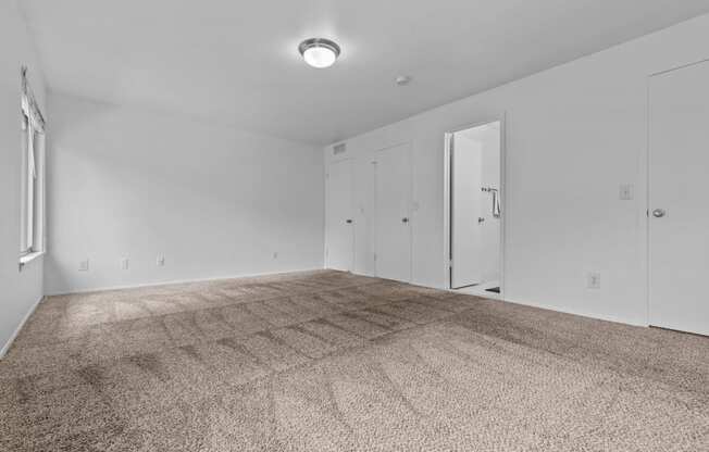 an empty living room with carpet and white walls at Edge At Farmington Hills - Farmington Hills, MI, Michigan