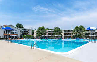 a swimming pool with umbrellas and buildings in the background at Copper and Quarry Village, Pikesville