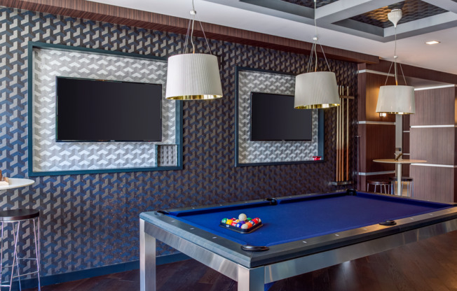 Modern glass-walled club room with pool table and fireplace