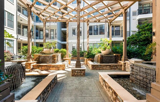 a courtyard with water fountain and seating in an apartment building