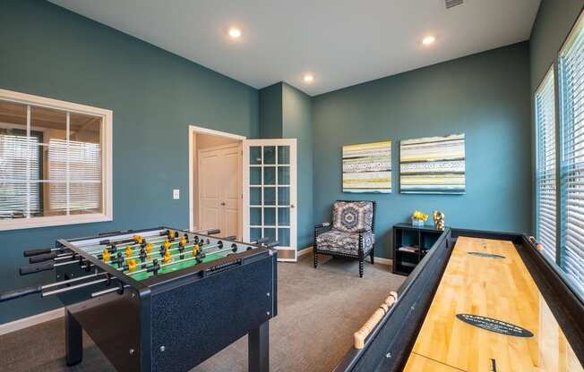 Game room with a foosball table and shuffle board at Mosaic Apartments in Avon, Indiana