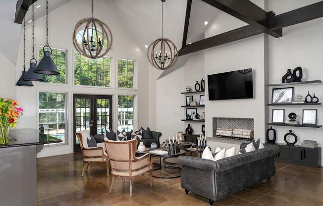 A modern living room with a grey sofa, a wooden table, and a TV mounted on the wall.
