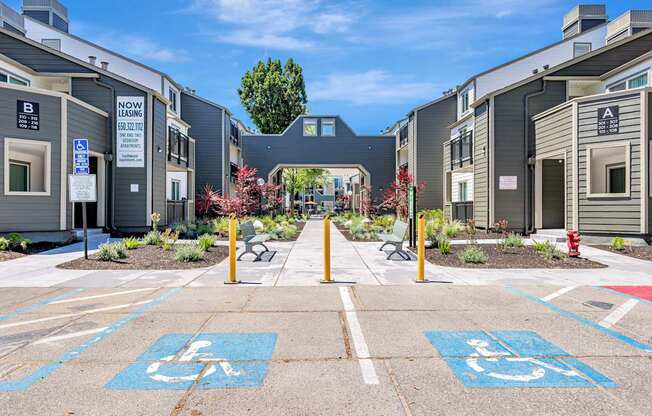 A parking lot with two handicap parking spaces in the foreground.