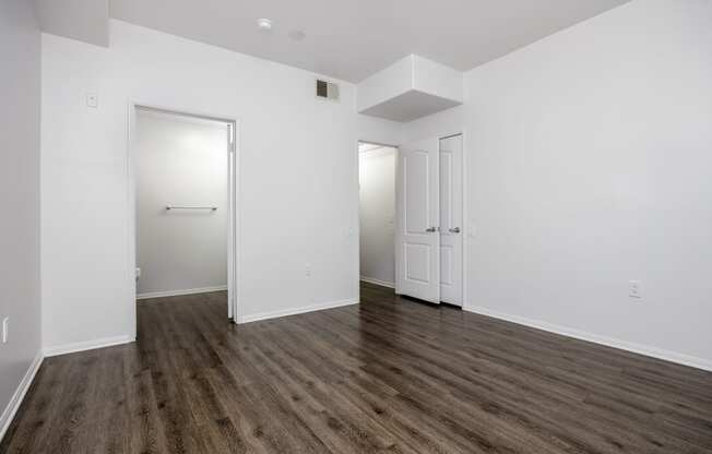 an empty living room with white walls and wood flooring