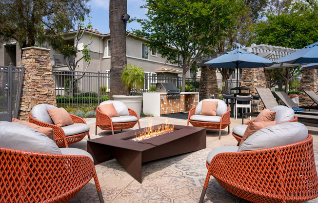 a patio with chairs and a table with a fire pit