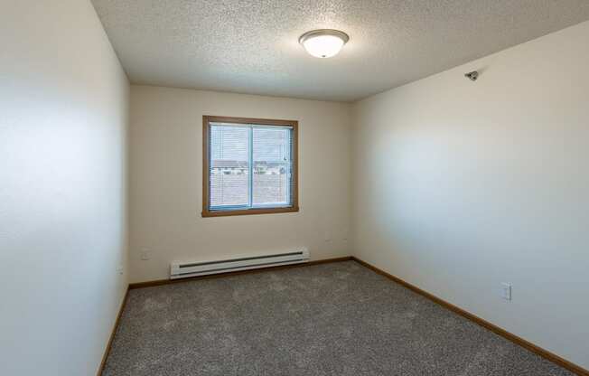 Fargo, ND Parkside Apartments. A bedroom with a window and carpet