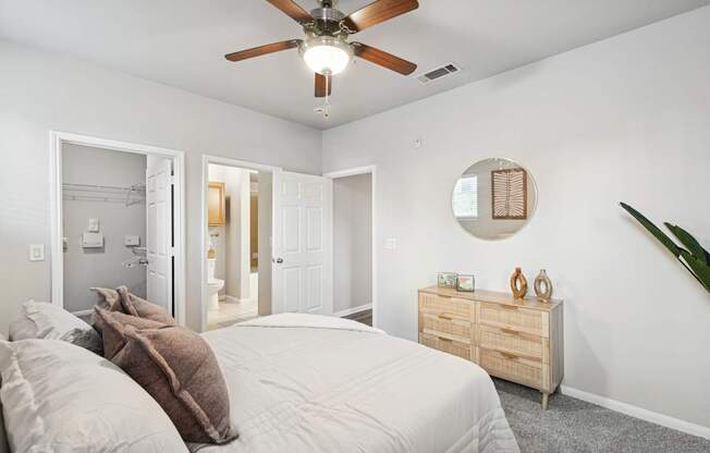 A bedroom with a bed, dresser, and mirror.