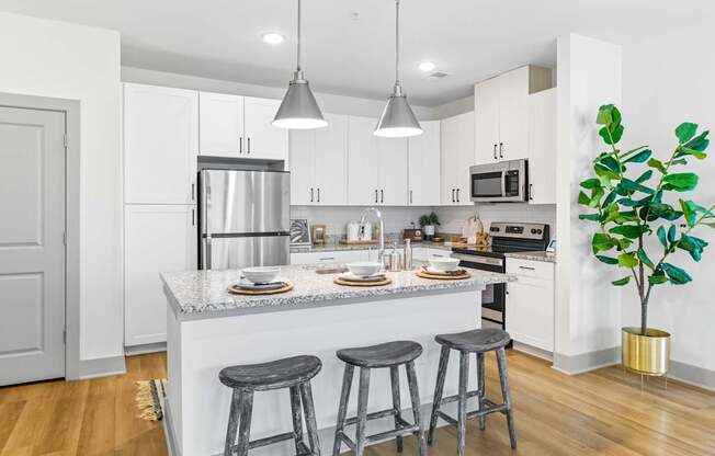 A kitchen with a white counter top and grey bar stools.