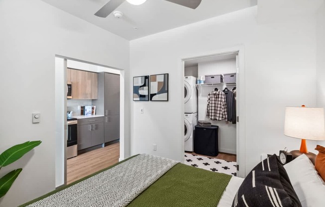 A bedroom with a bed, a green rug, and a ceiling fan.