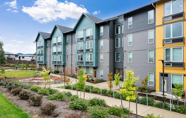 an exterior view of an apartment building with a garden