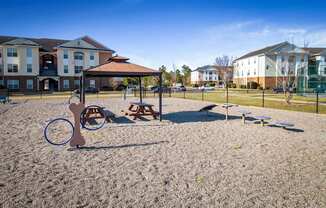 a playground with a swing set and benches in front of houses