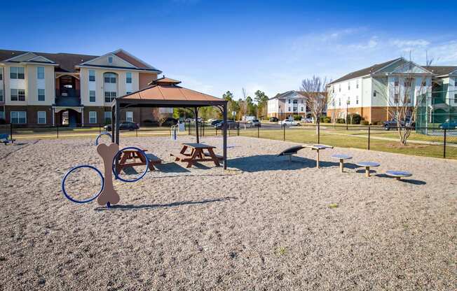 a playground with a swing set and benches in front of houses