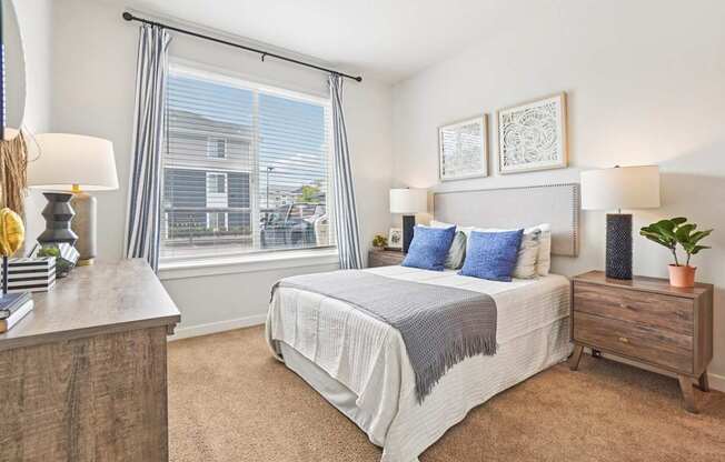A bedroom with a large bed and a window with blinds. at Connect at First Creek Apartments, Colorado, 80249