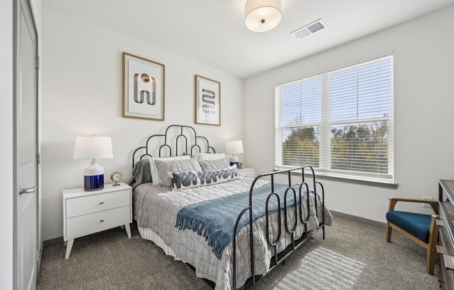 a bedroom with a bed and a large window at The Quarry Luxury Apartment Homes, Fort Collins, Colorado