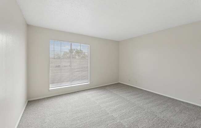 A2 Bedroom with big window and carpet flooring at Westdale Pointe in Austin, TX