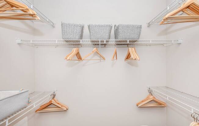a walk in closet with shelves and clothes racks
